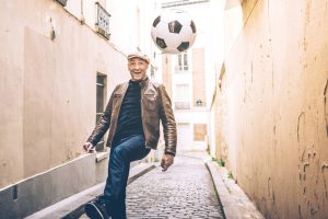 happy french man playing soccer in Paris street